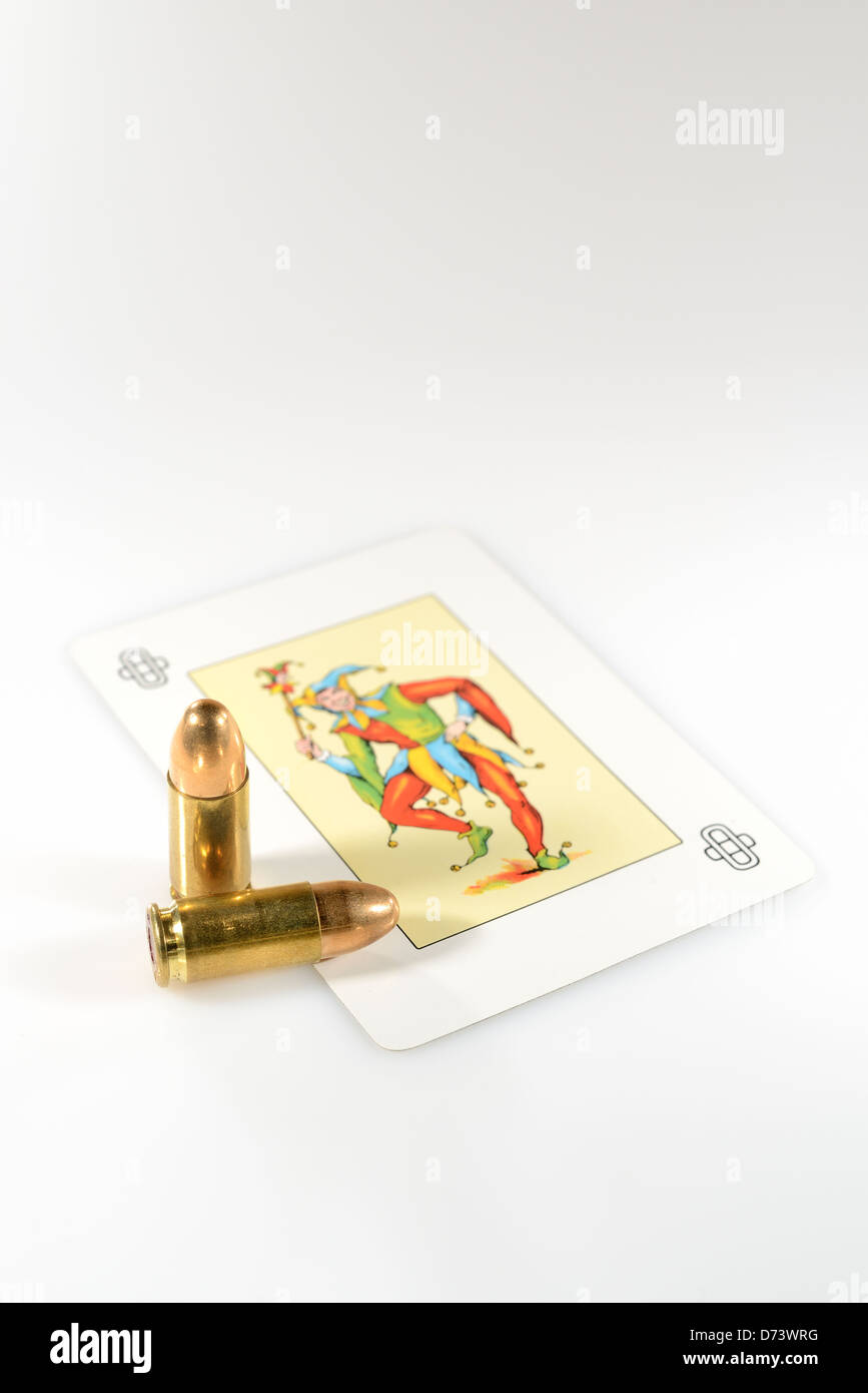 Joker card and two bullets on white background Stock Photo