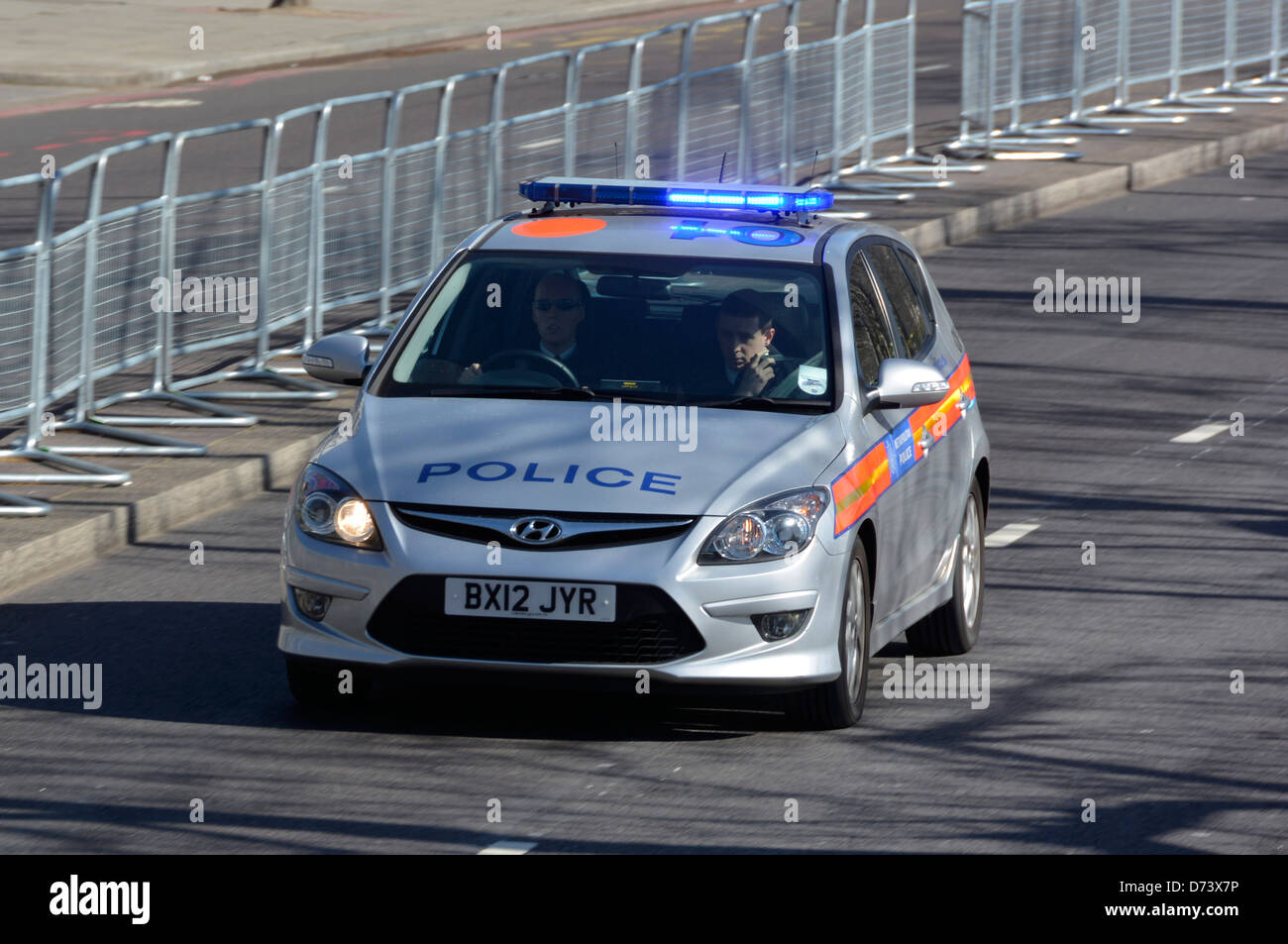Metropolitan police car at speed with blue flashing lights and two man