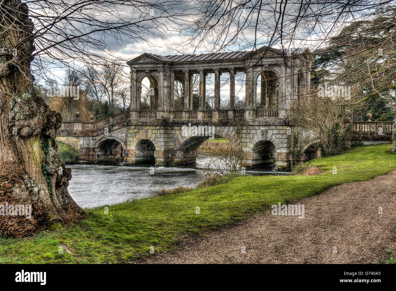 Wilton House Palladian bridge is the home of the Earl of Pembrook and with the stormy sunlit clouds gives a classic look to it Stock Photo