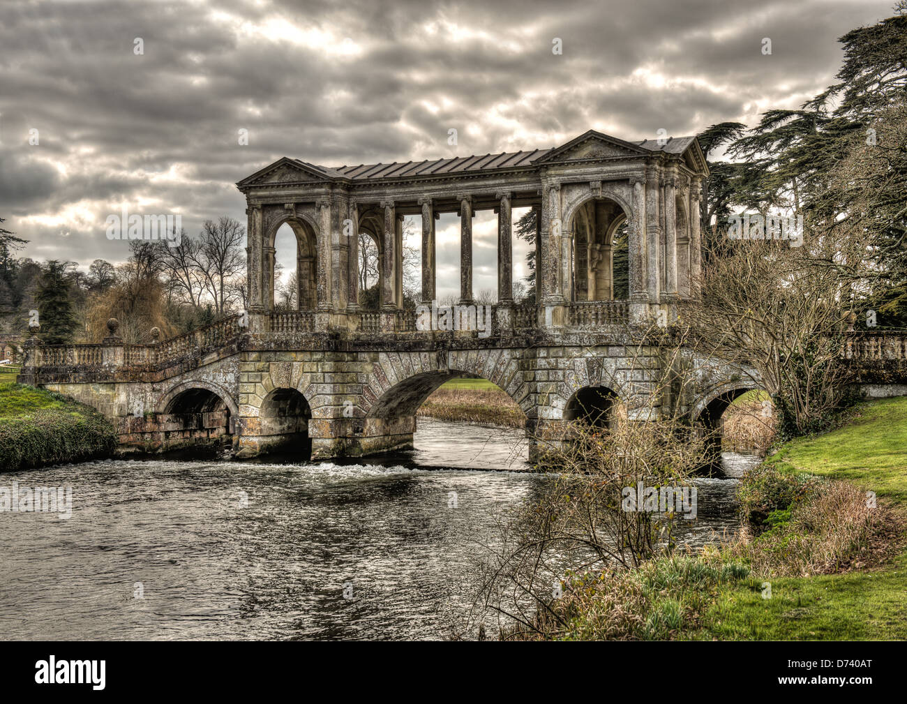 Wilton House Palladian bridge is the home of the Earl of Pembrook and with the stormy sunlit clouds gives a classic look to it Stock Photo