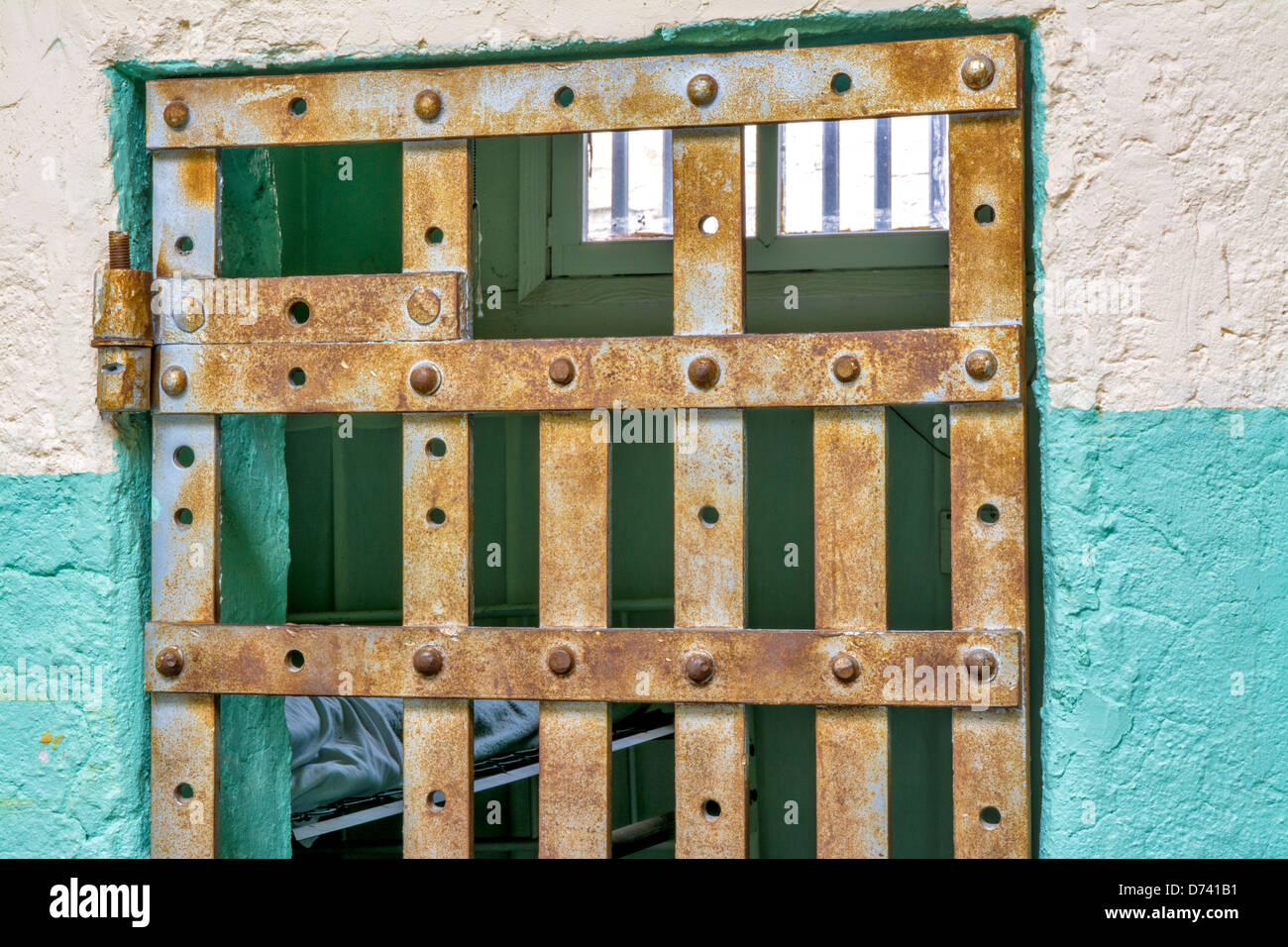 Jail cell bed and bars Stock Photo