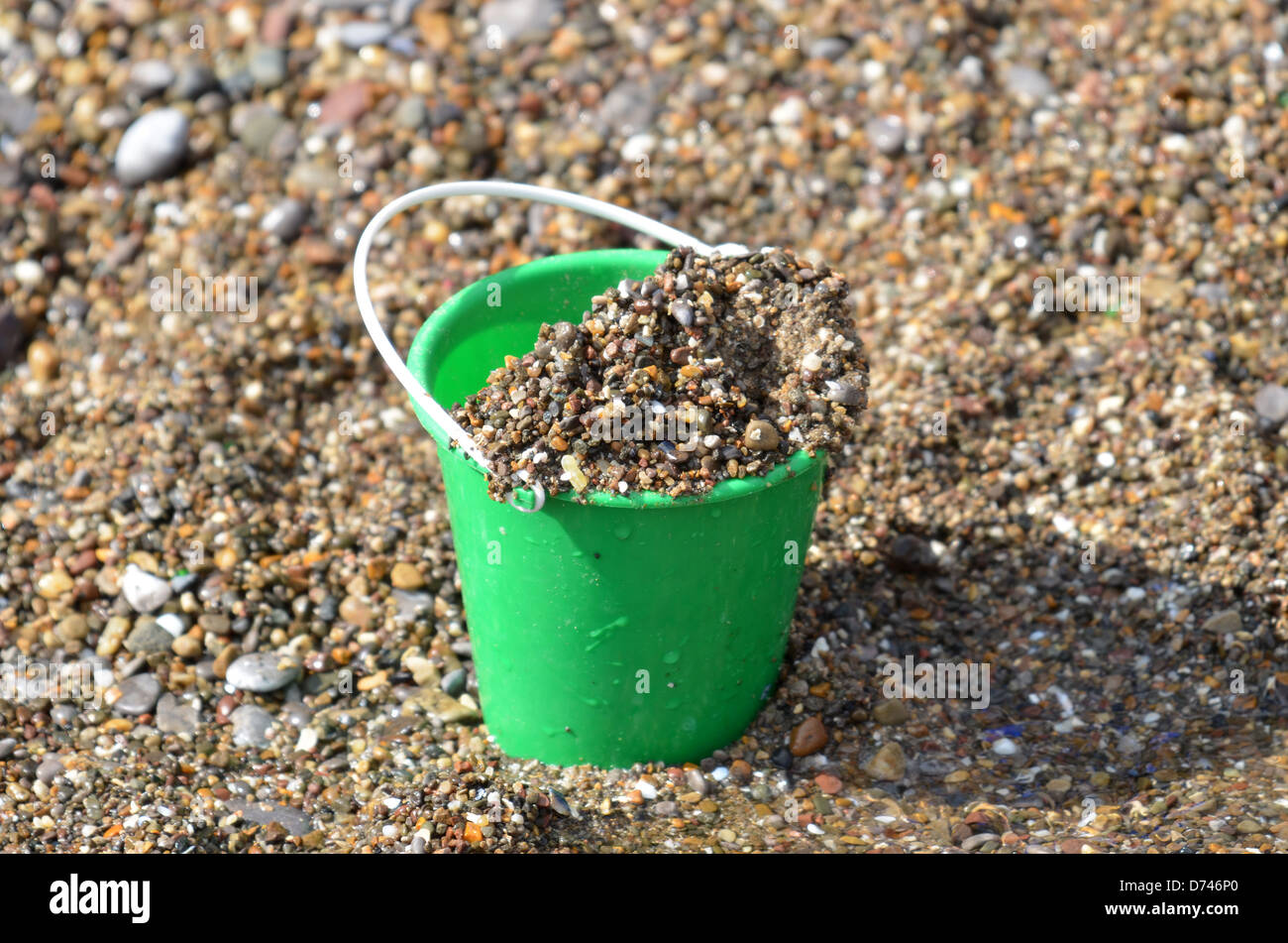Bucket of gravelly sand on beach number 3298 Stock Photo