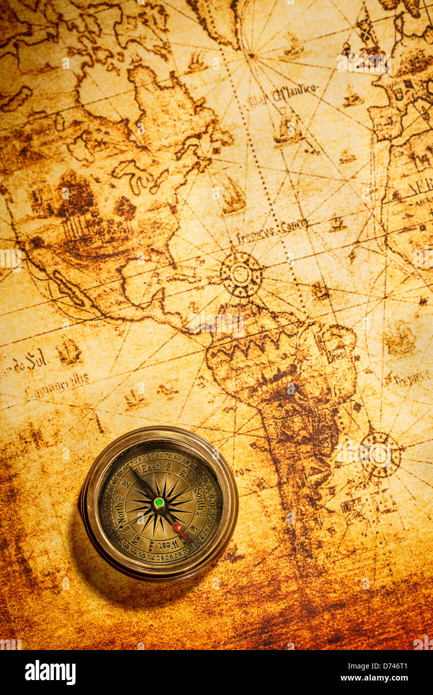 Vintage still life. Vintage compass lies on an ancient world map. Stock Photo