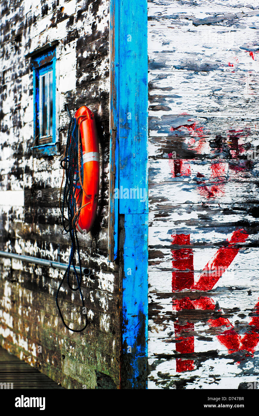 Lifebuoy hanging on the wall of an old shed Stock Photo