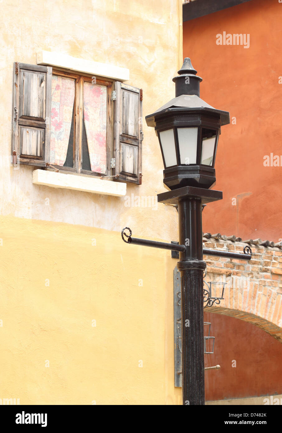 ancient lamppost with vintage window and wall background Stock Photo