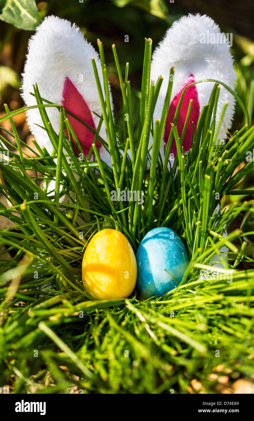 The Easter Bunny hides behind a tall bunch of grass where Easter Eggs