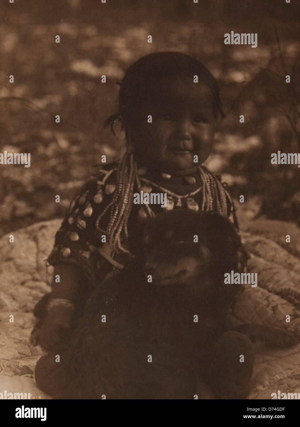 This photograph depicts a Native American child with a dog. The image captures a moment in Native American life, reflecting the cultural heritage and everyday experiences of Indigenous communities. Stock Photo