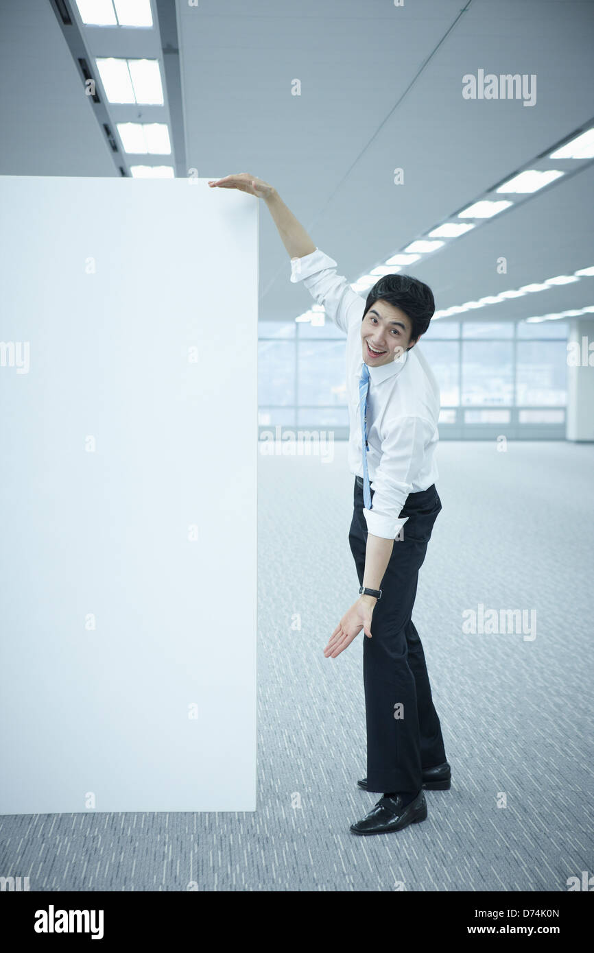 a businessman measuring the length of an empty whiteboard Stock Photo