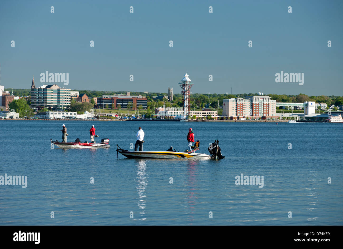 PEOPLE FISHING IN SMALL BOATS DOWNTOWN ERIE SKYLINE FROM PRESQUE ISLE STATE PARK ERIE PENNSYLVANIA USA Stock Photo