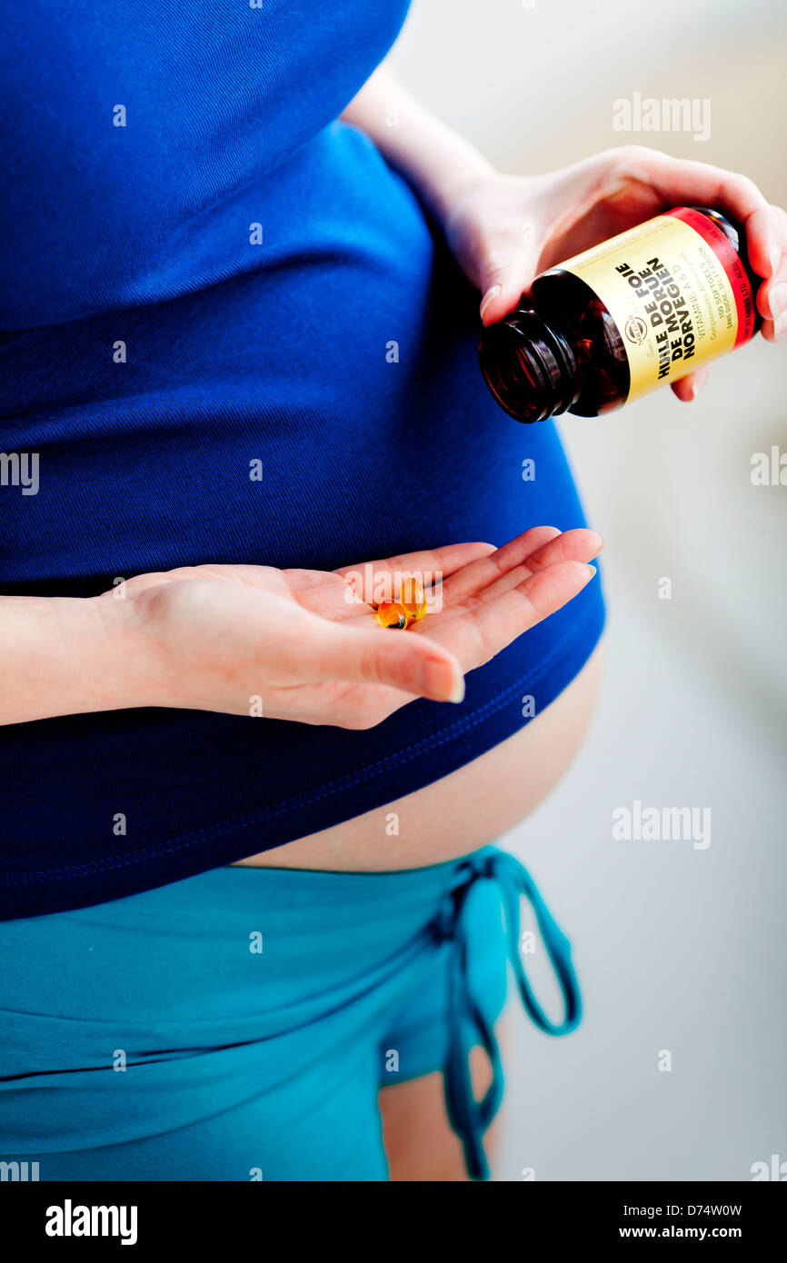 Pregnant woman taking cod liver oil gelatine capsules Stock Photo Alamy