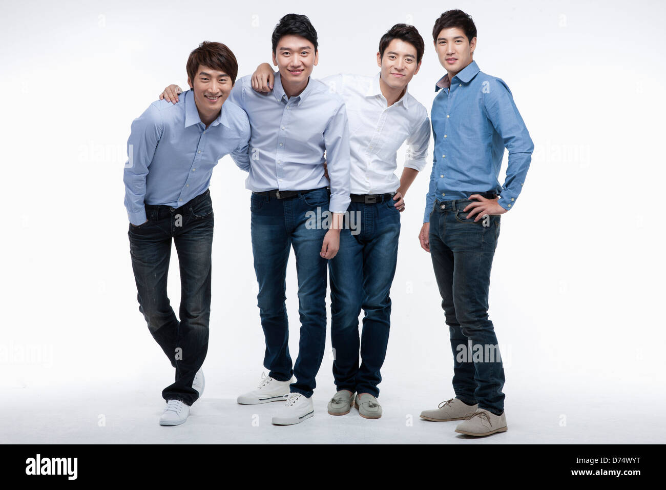 four men with shirts and jeans posing at camera Stock Photo - Alamy