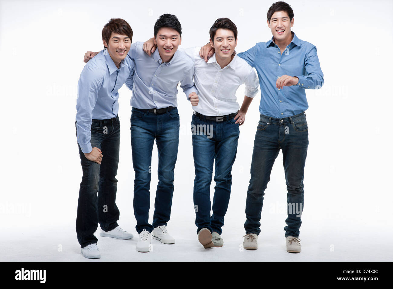 four men with shirts and jeans posing at camera Stock Photo - Alamy