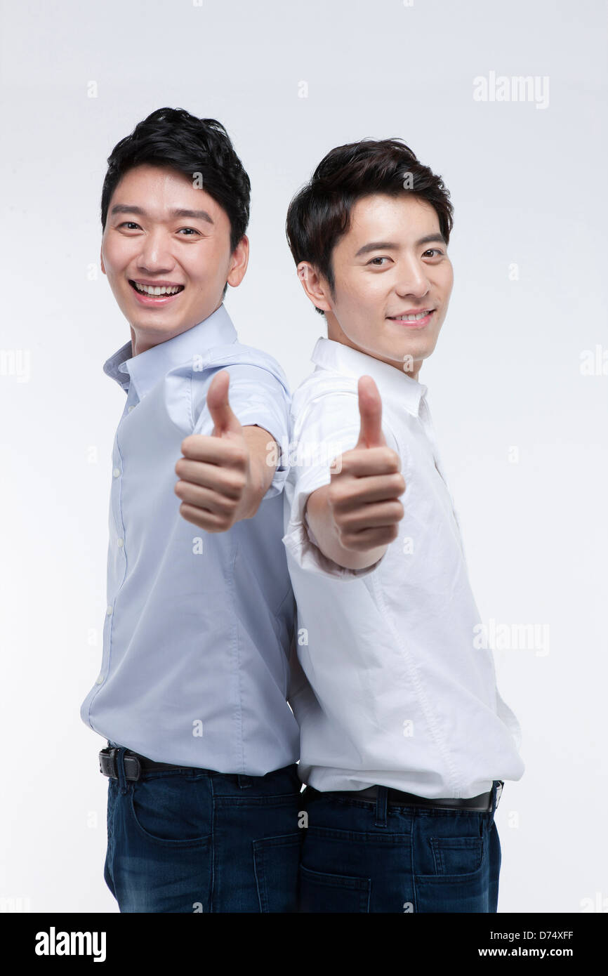 two men with shirts and jeans showing thumbs up in camera Stock Photo ...