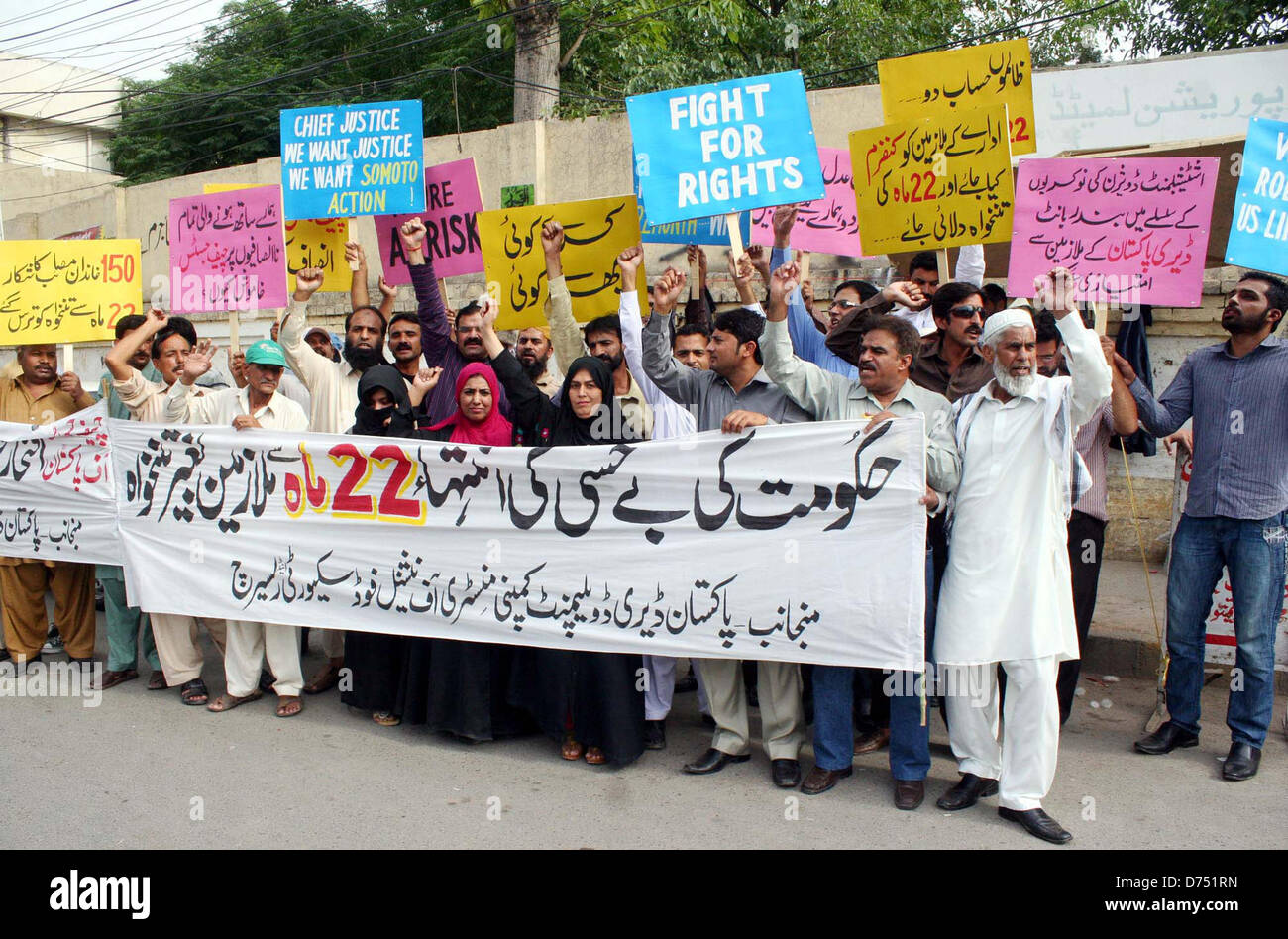 Members of Pakistan Diary Development Company Ministry of National Food Security Research chant slogans against nonpayment of their salaries and demanding to release their dues immediately during a protest demonstration at Lahore press club on Monday, April 29, 2013. Stock Photo