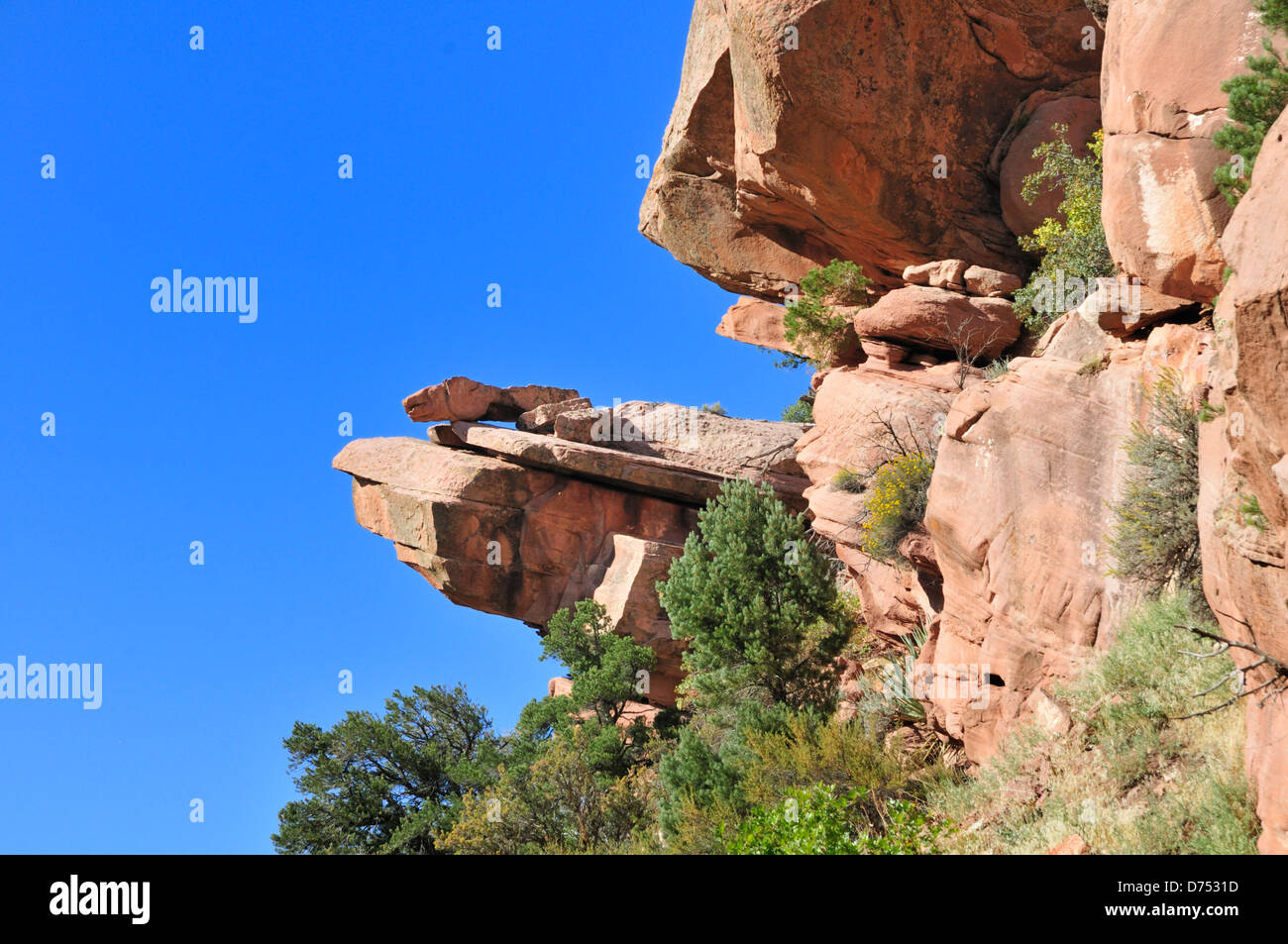 Small rocks rest on a rock shelf protruding from a steep cliff in the Kolob Canyons section of
