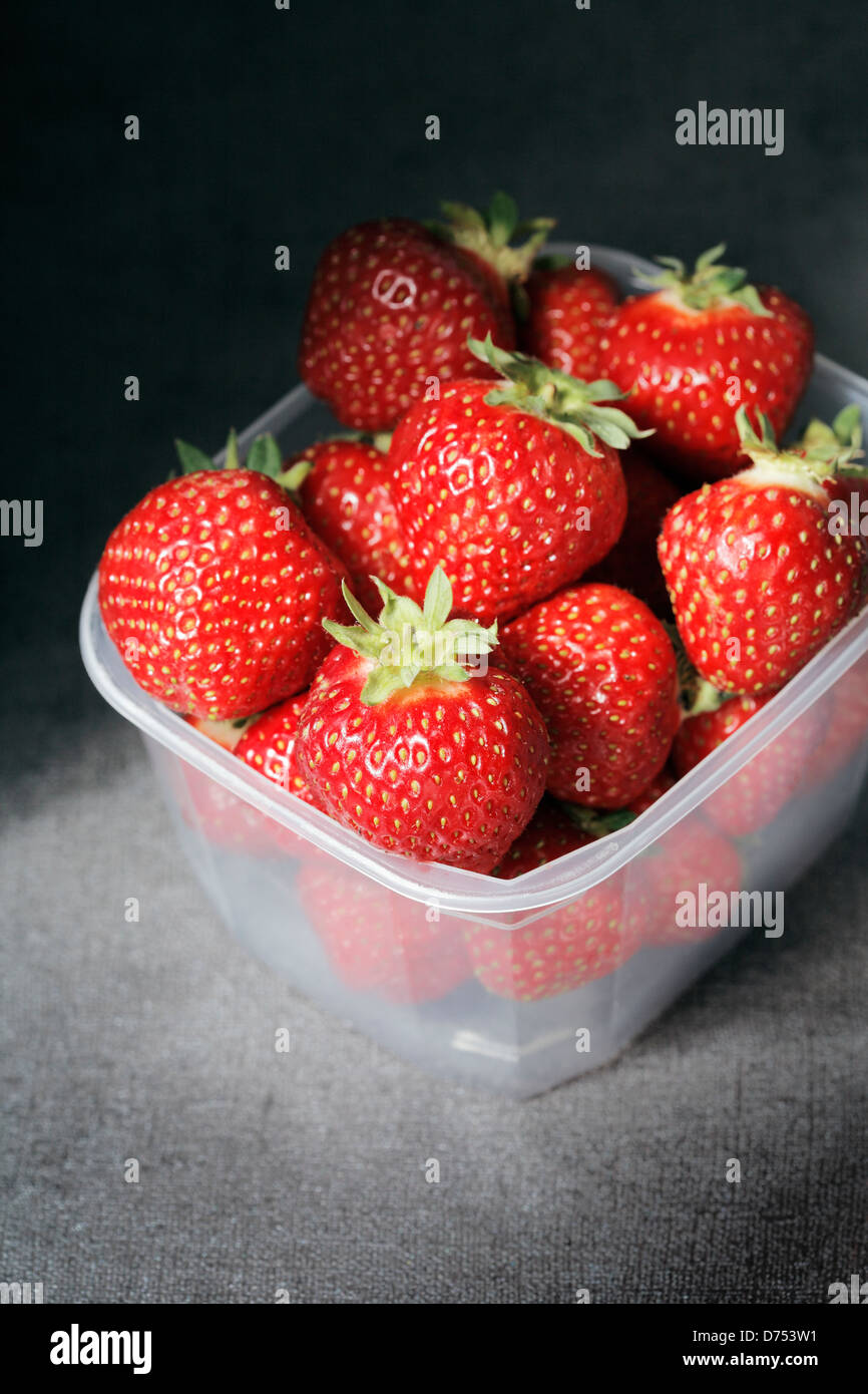 Strawberries in a plastic container. Short depthoffield Stock Photo