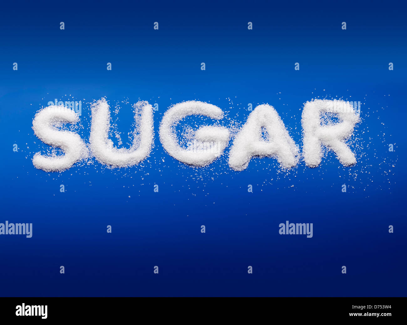 Word Sugar written with real fine granulated sugar on blue background. Stock Photo