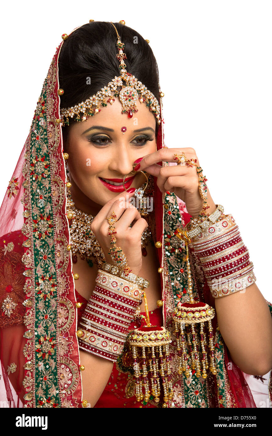 indian bride in traditional wedding dress adjusting her nose ring D755X0