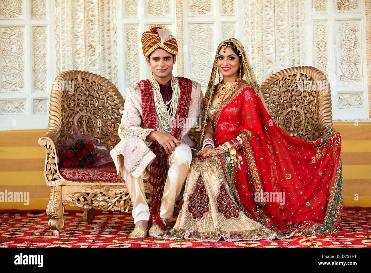 Indian Bride And Groom In Traditional Wedding Dress Sitting On A