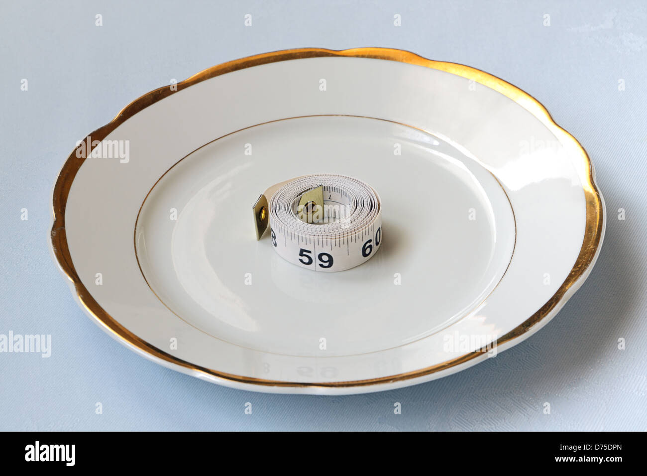 Roll of white centimeter on white china ware Stock Photo