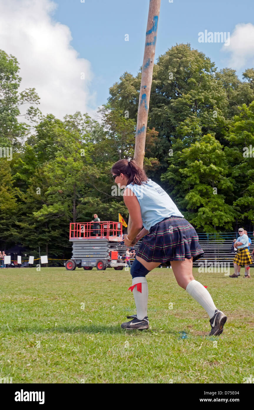 Woman performing Caber toss during Scottish Highland games Stock Photo