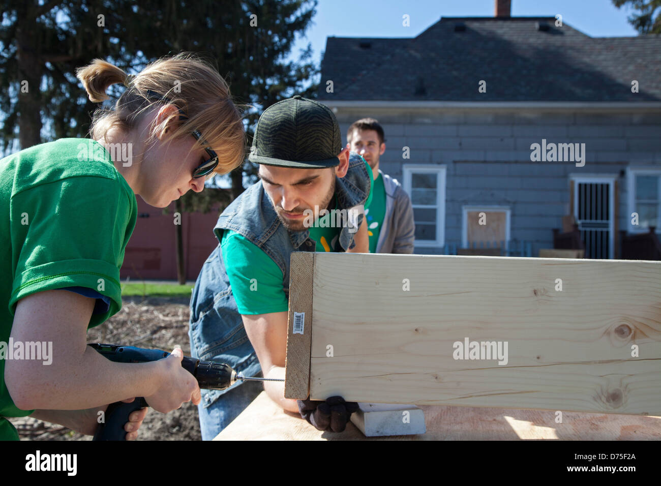 Volunteers build raised boxes for a community garden Stock Photo