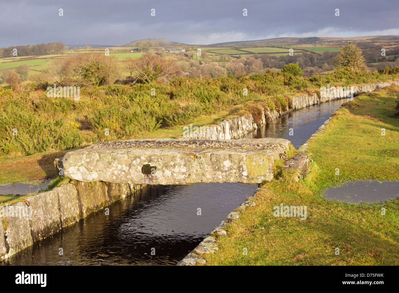 Granite stone forming bridge across manmade leat on Dartmoor, Devon UK Stock Photo