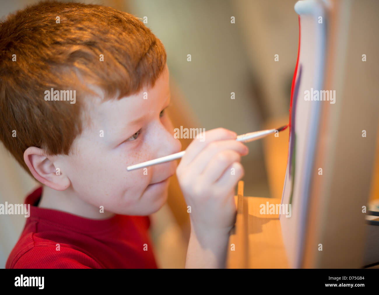 Boy painting at an easel Stock Photo