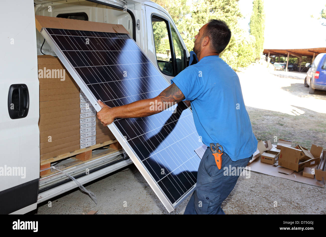 Torre Alfina, Italy, man brings a solar collector from a van Stock Photo