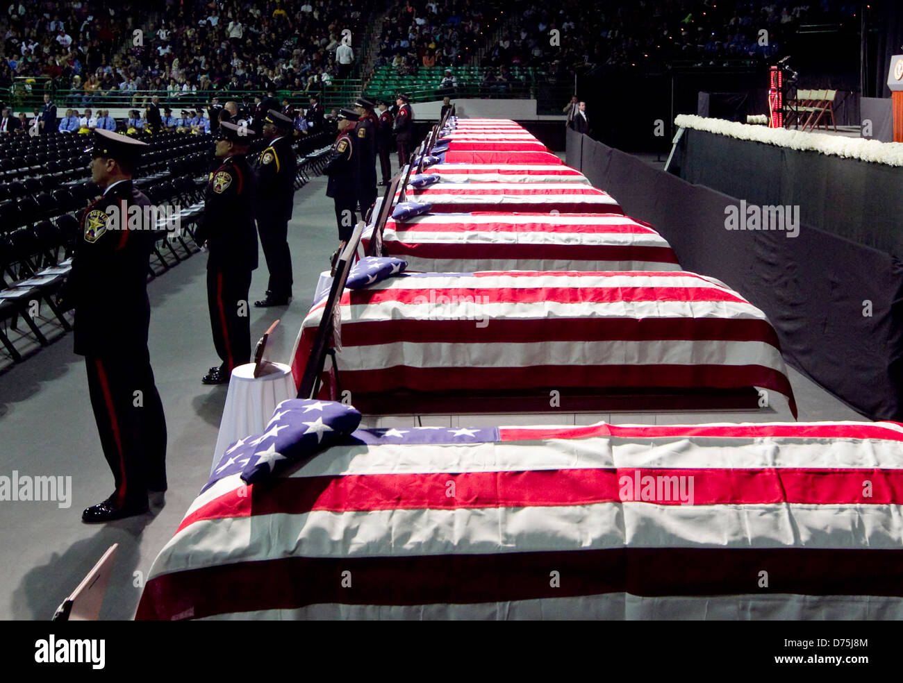 Firefighters stand guard in front of caskets covered in US flags during memorial service in Waco, Texas Stock Photo
