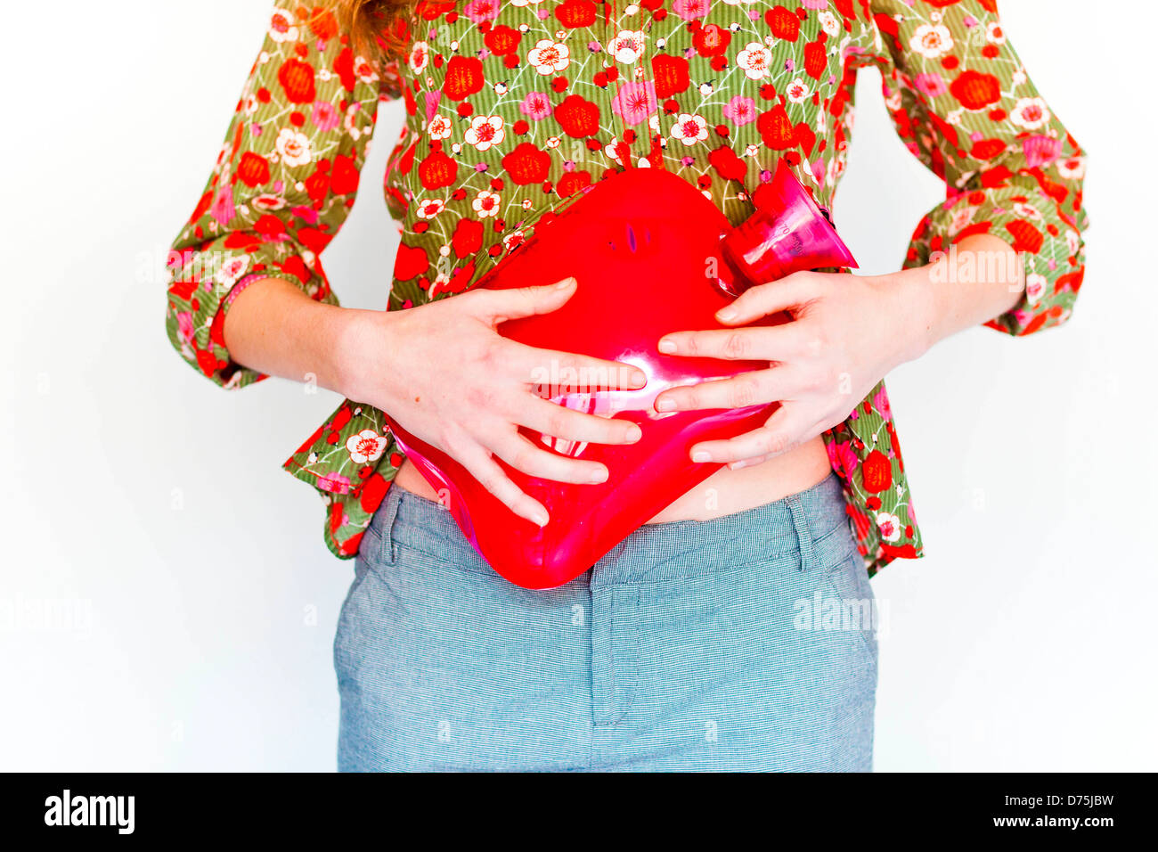 woman using a hotwater bottle on her belly to releive abdominal pain