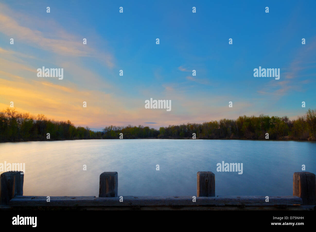 Sunset over boat dock at Veterans Memorial State Park with lake waters smoothed by long exposure, Boise, Idaho Stock Photo