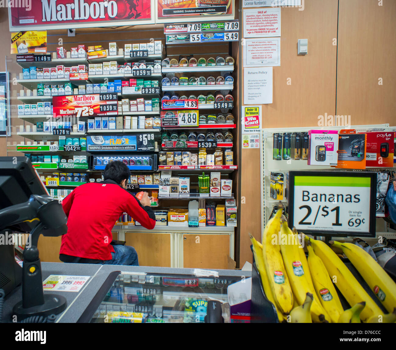 A clerk stocks cigarettes in convenience store in New York Stock Photo