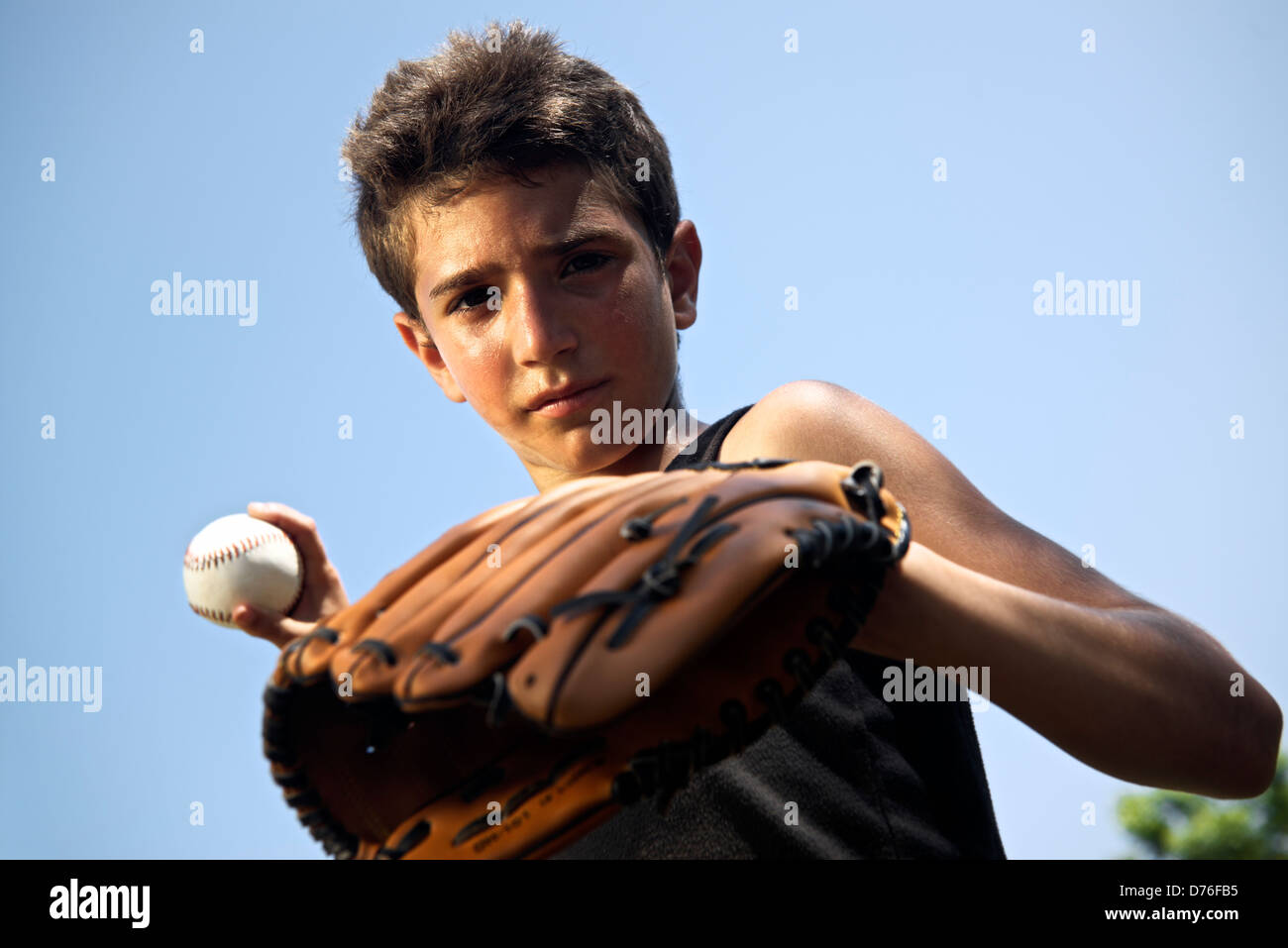 A Boy Holding A Baseball Bat And Wearing A Glove Stock Photo