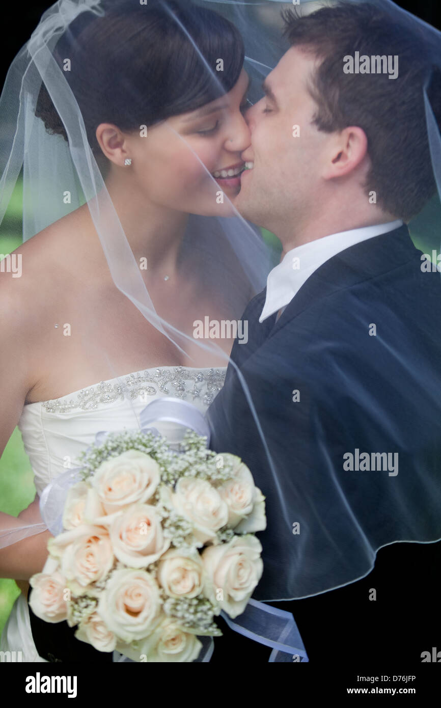 Newlywed Couple Kissing Stock Photo - Alamy