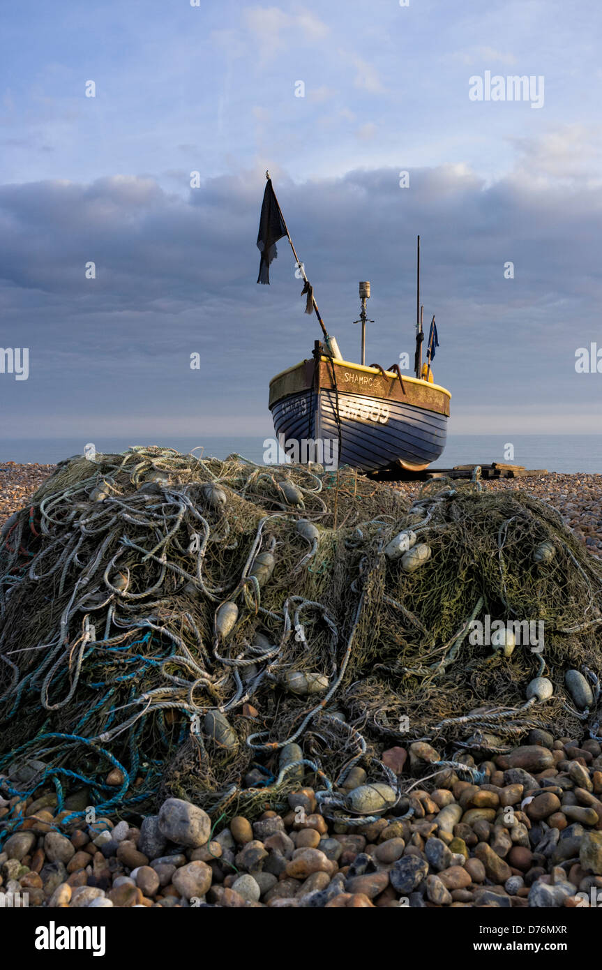 Small open fishing boat on Eastbourne beach in the evening sun Stock