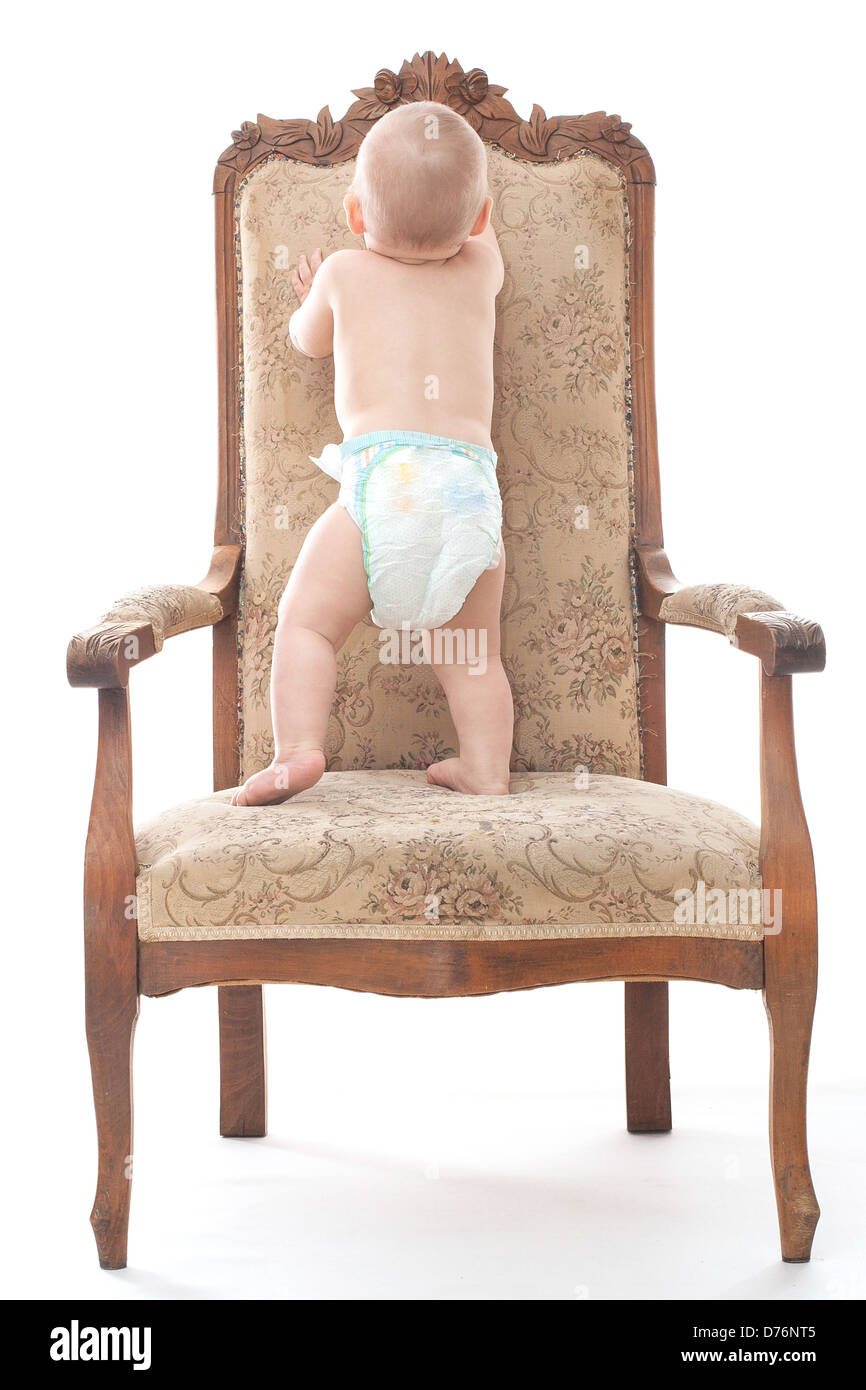 Little boy climbs on the retro chair Stock Photo