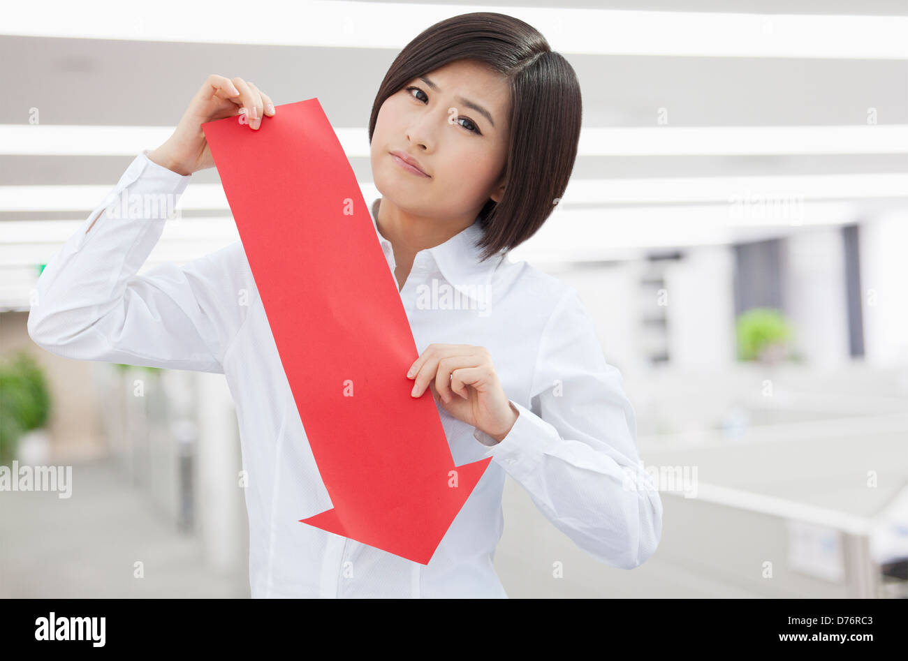 Young Woman Holding Arrow Sign Paper Cut Stock Photo - Alamy
