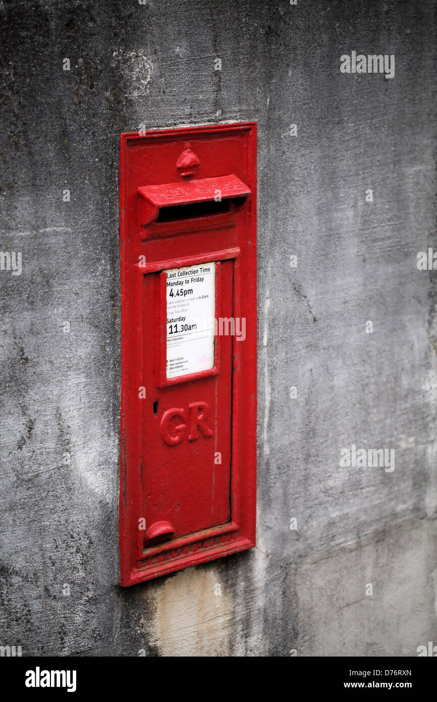 Red British Royal Mail letter box in a grey concrete wall on Barnoon Hill, St. Ives, Cornwall Stock Photo