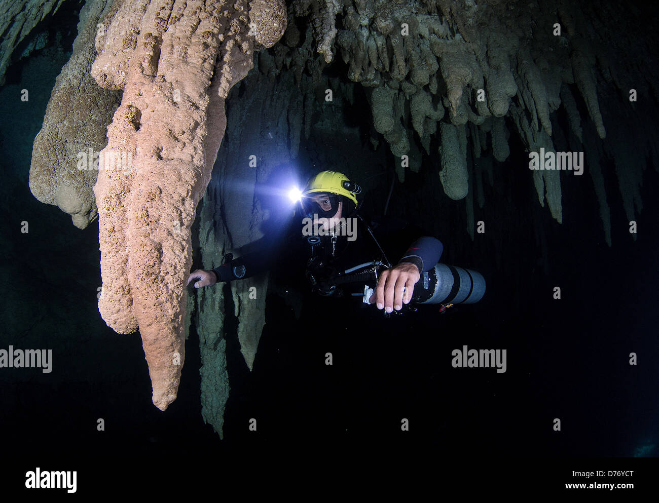 Mexico Puerto Morelos Scuba diver descending in deep cenote among