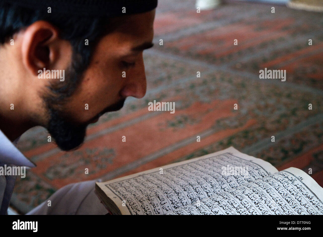 A young man read Quran in a mosque in Lahore, Pakistan. Stock Photo