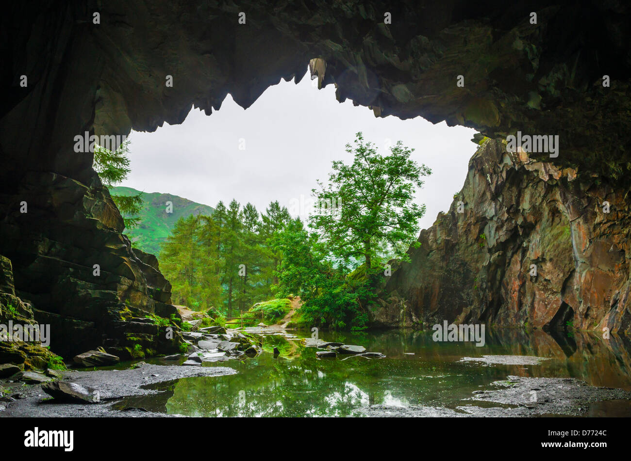 The mouth of an abandoned quarry cave on Loughrigg Fell in the Lake District, Cumbria, England. Stock Photo