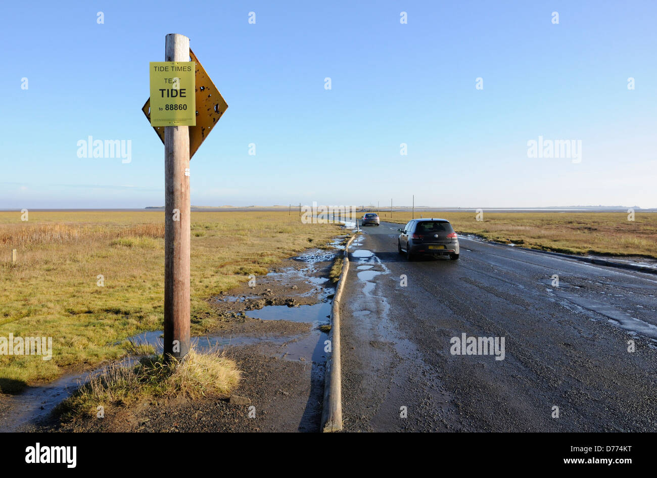 Cars driving on the causeway to Holy Island Stock Photo