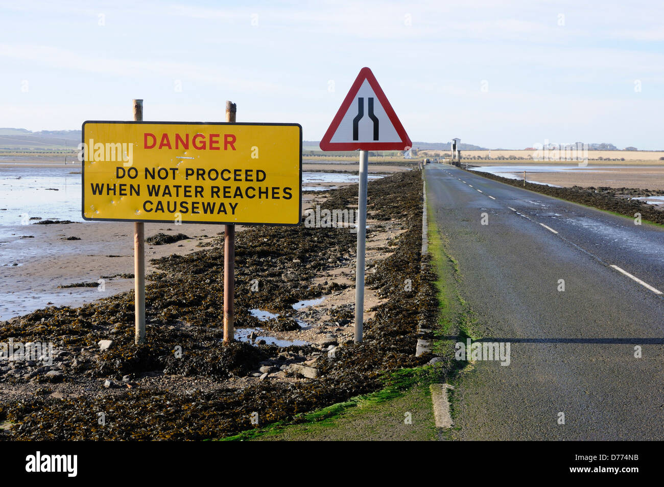 Danger signs on the causeway to Holy Island Stock Photo