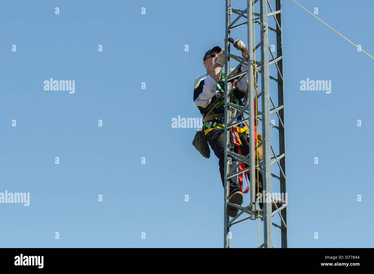 Man climbing antenna tower during amateur radio tower installation