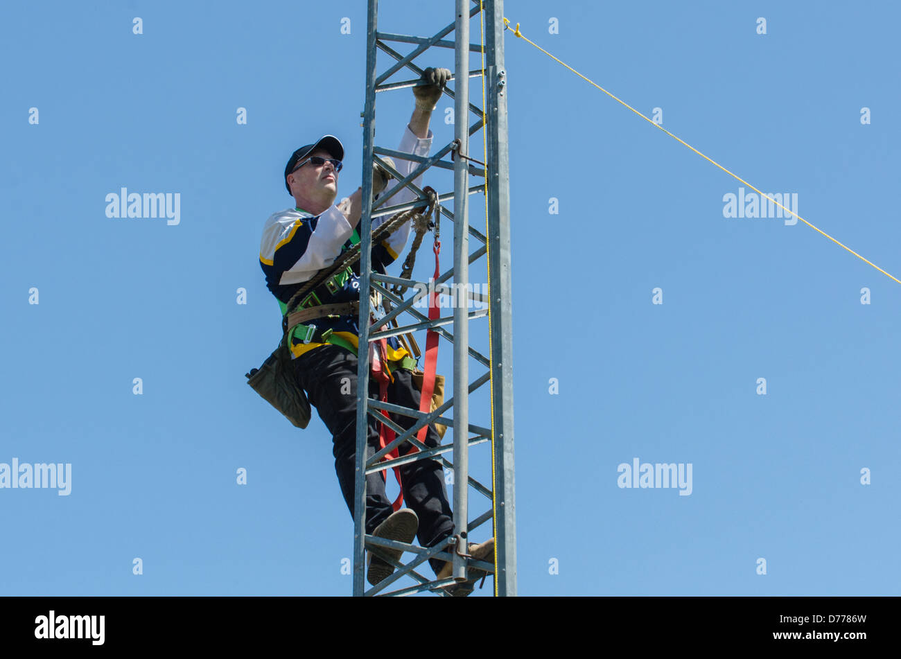 Man climbing antenna tower during amateur radio tower installation. Stock Photo