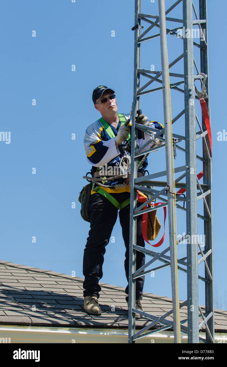 Man climbing antenna tower during amateur radio tower installation