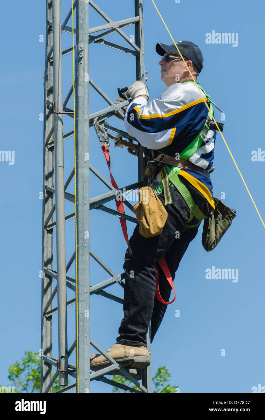 Man climbing antenna tower during amateur radio tower installation. Stock Photo