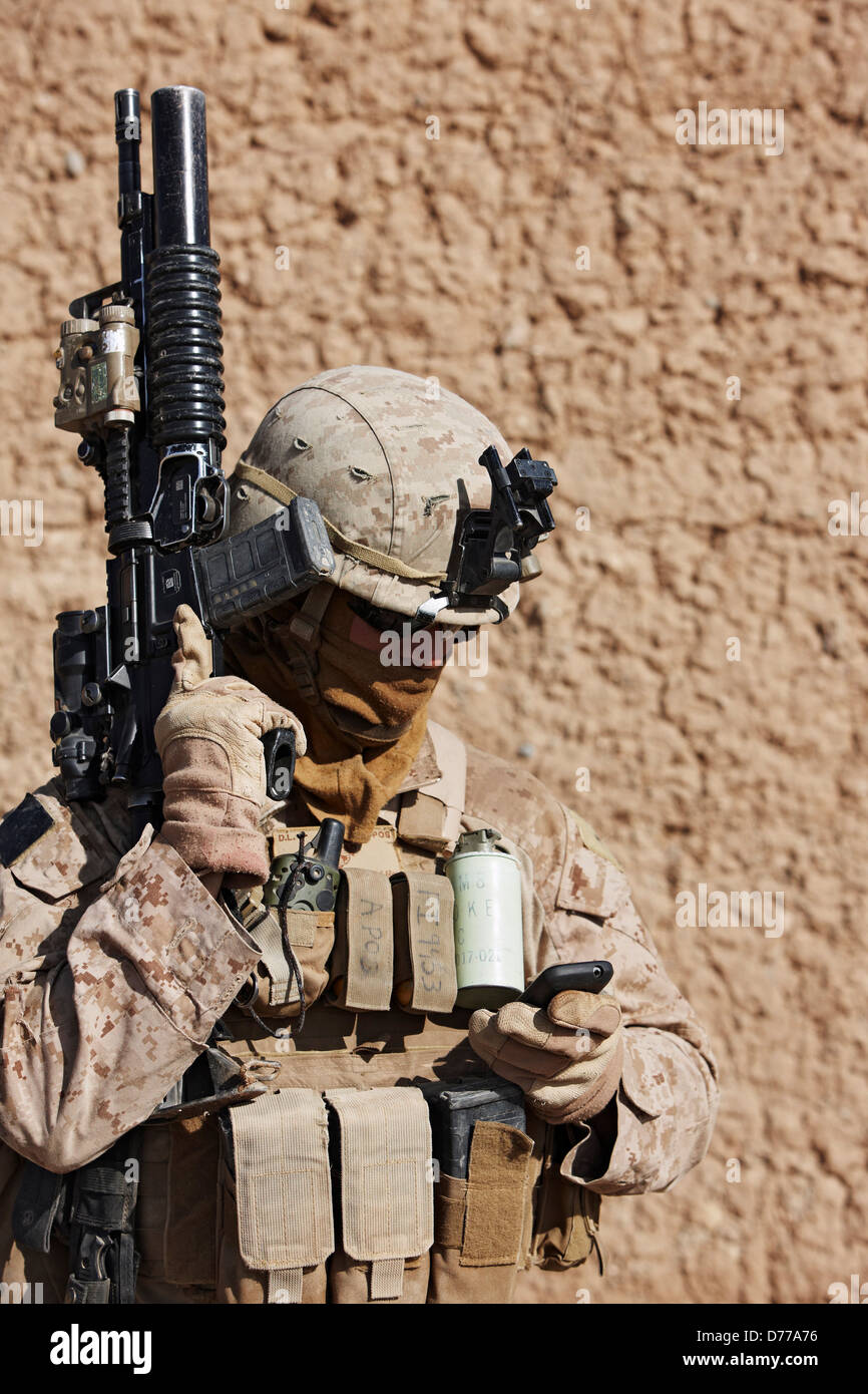 A U.S. Marine Sends Text Message on Cellular Smartphone Before Combat Operation in Afghanistan's Helmand Province Stock Photo