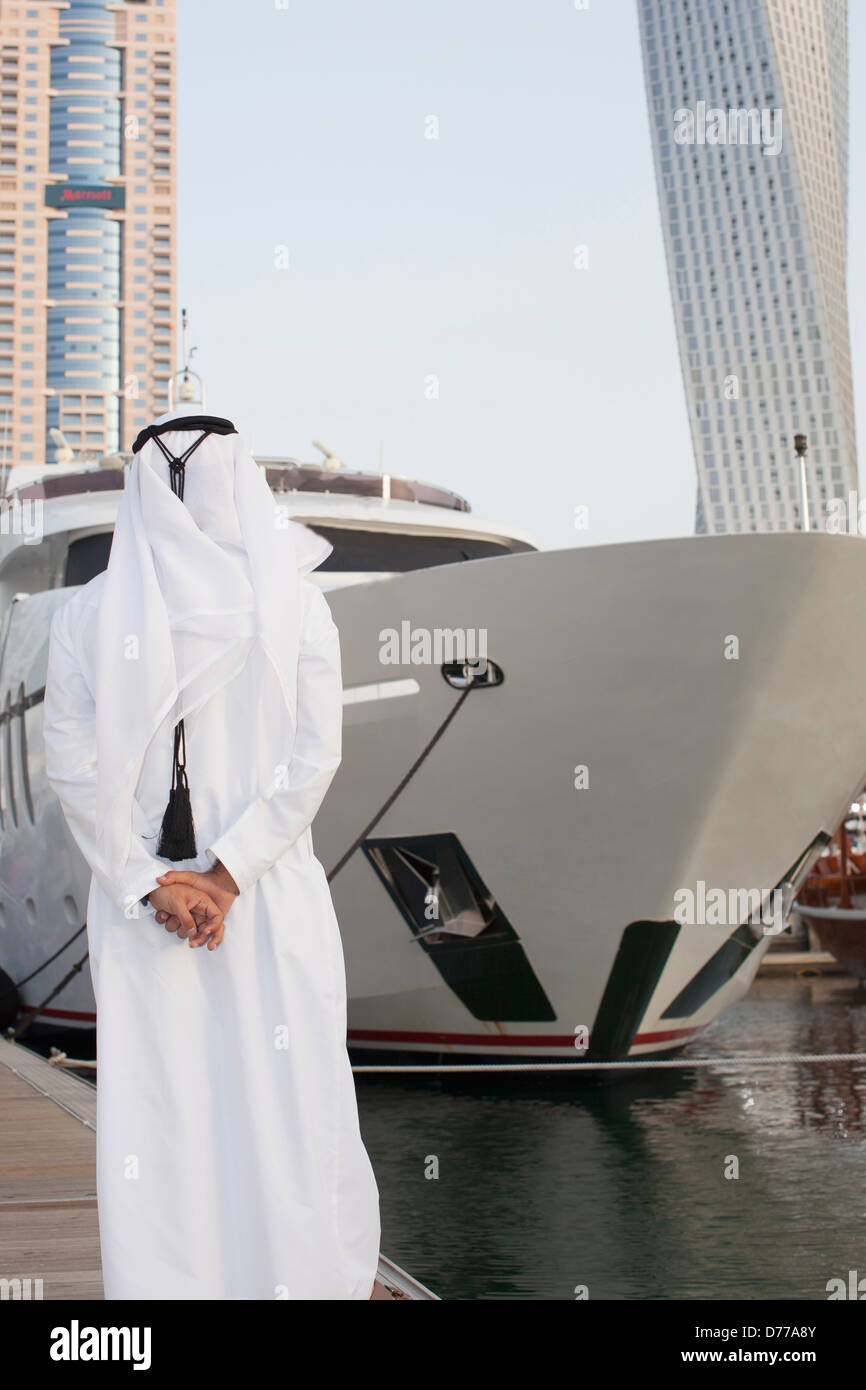 Arab man looking at yachts in Dubai Stock Photo